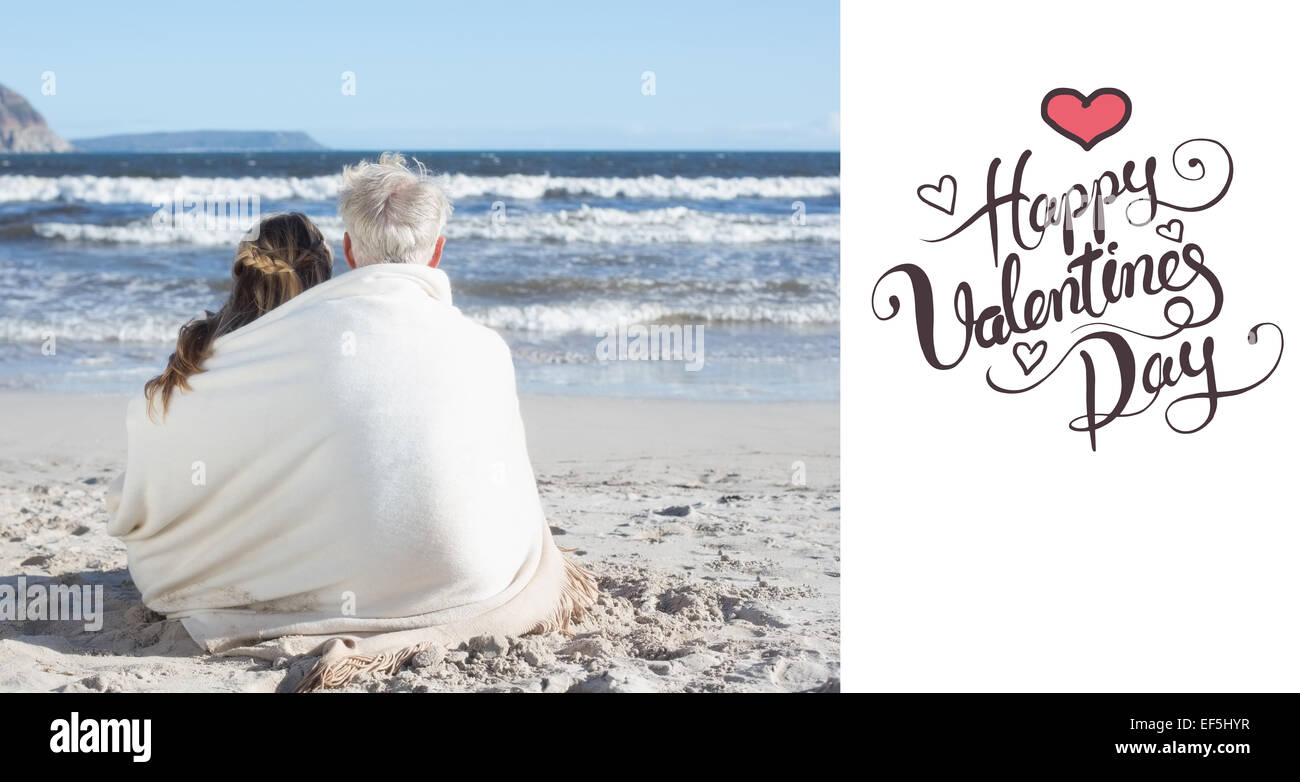 Composite image of couple sitting on the beach under blanket looking ...