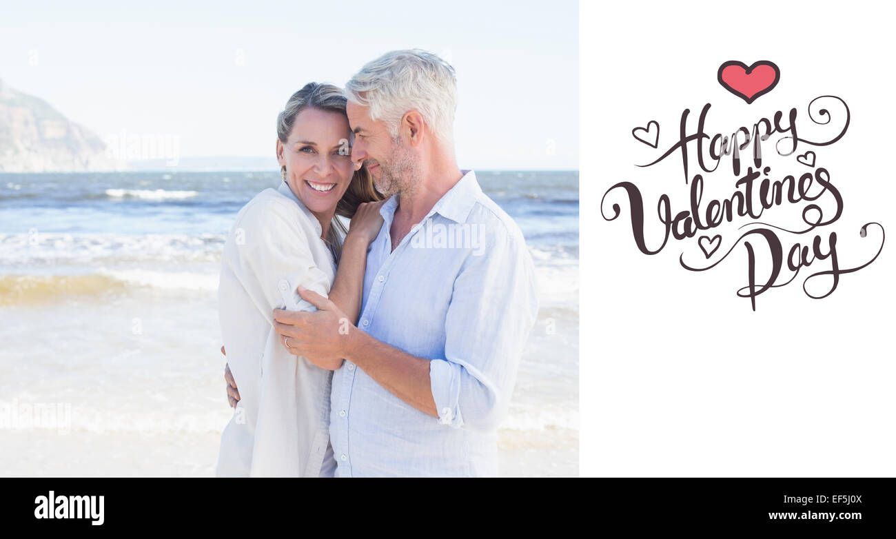 Composite image of happy couple hugging on the beach woman looking at camera Stock Photo