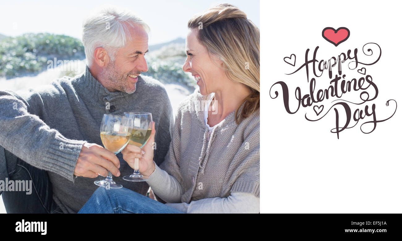 Composite image of couple enjoying white wine on picnic at the beach ...
