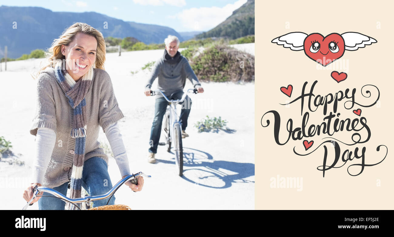 Composite image of carefree couple going on a bike ride on the beach Stock Photo