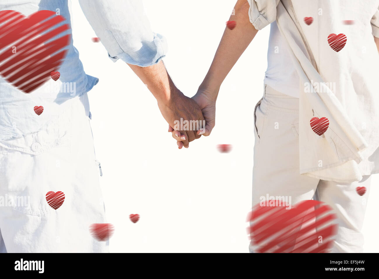 Composite image of couple on the beach looking out to sea holding hands ...