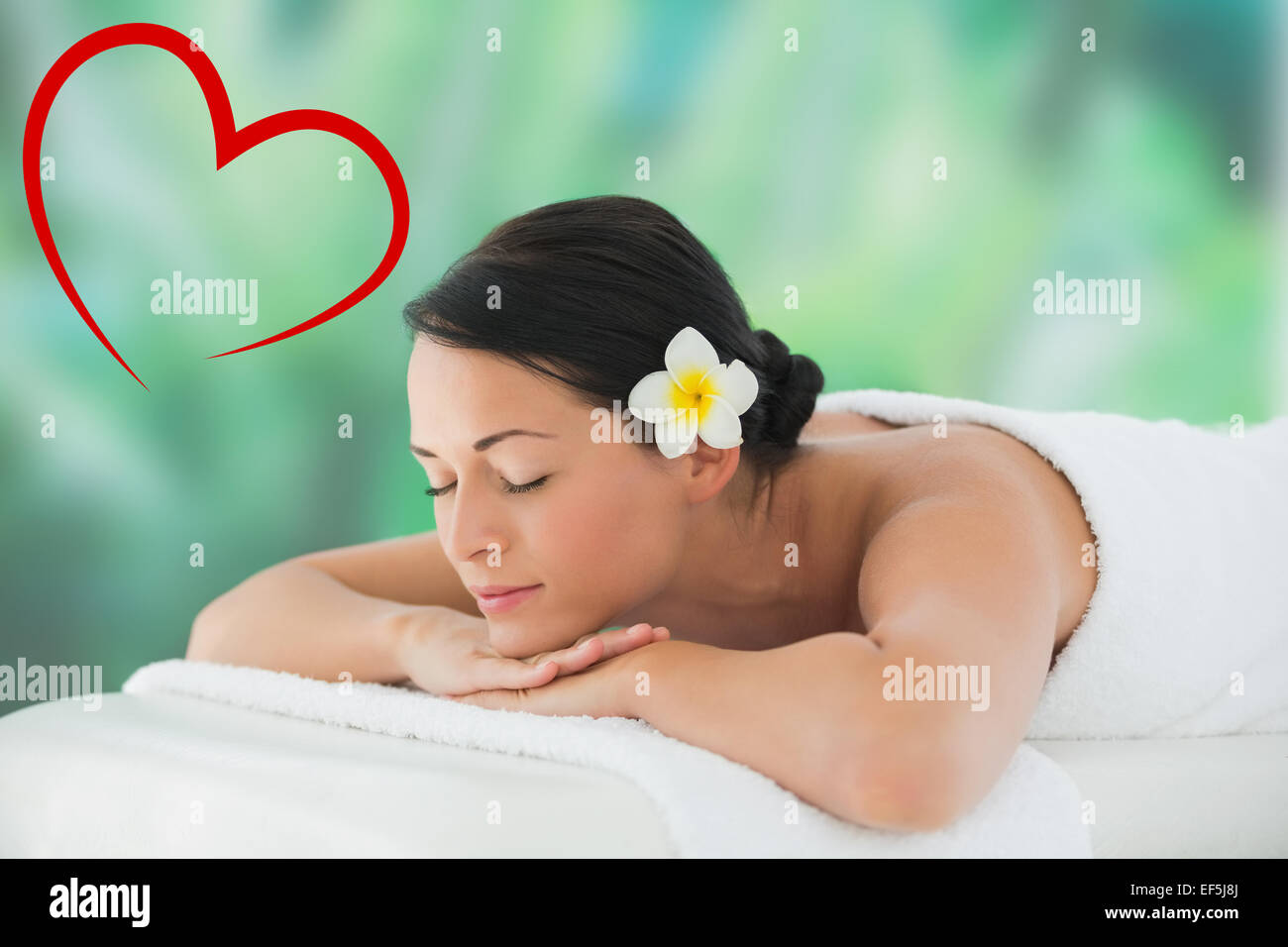 Composite image of beautiful brunette relaxing on massage table Stock Photo