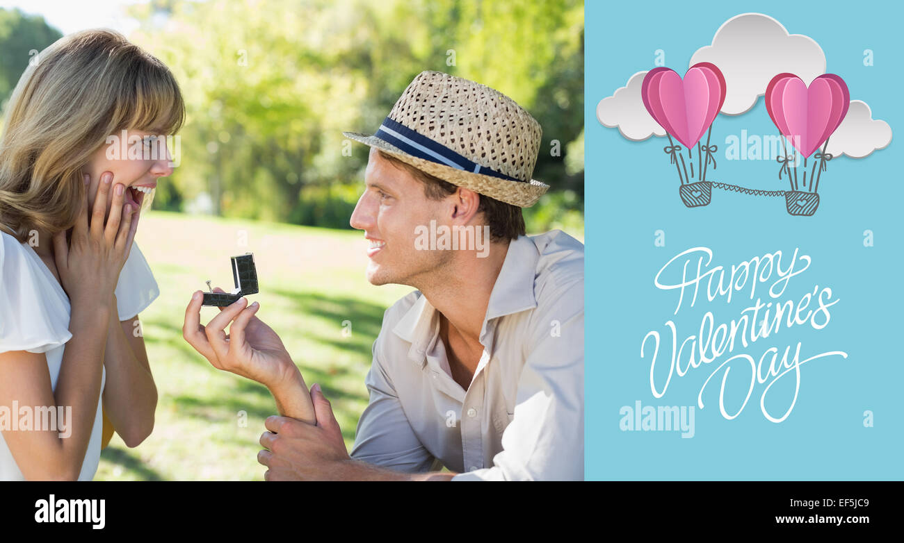 Composite image of man surprising his girlfriend with a proposal in the park Stock Photo