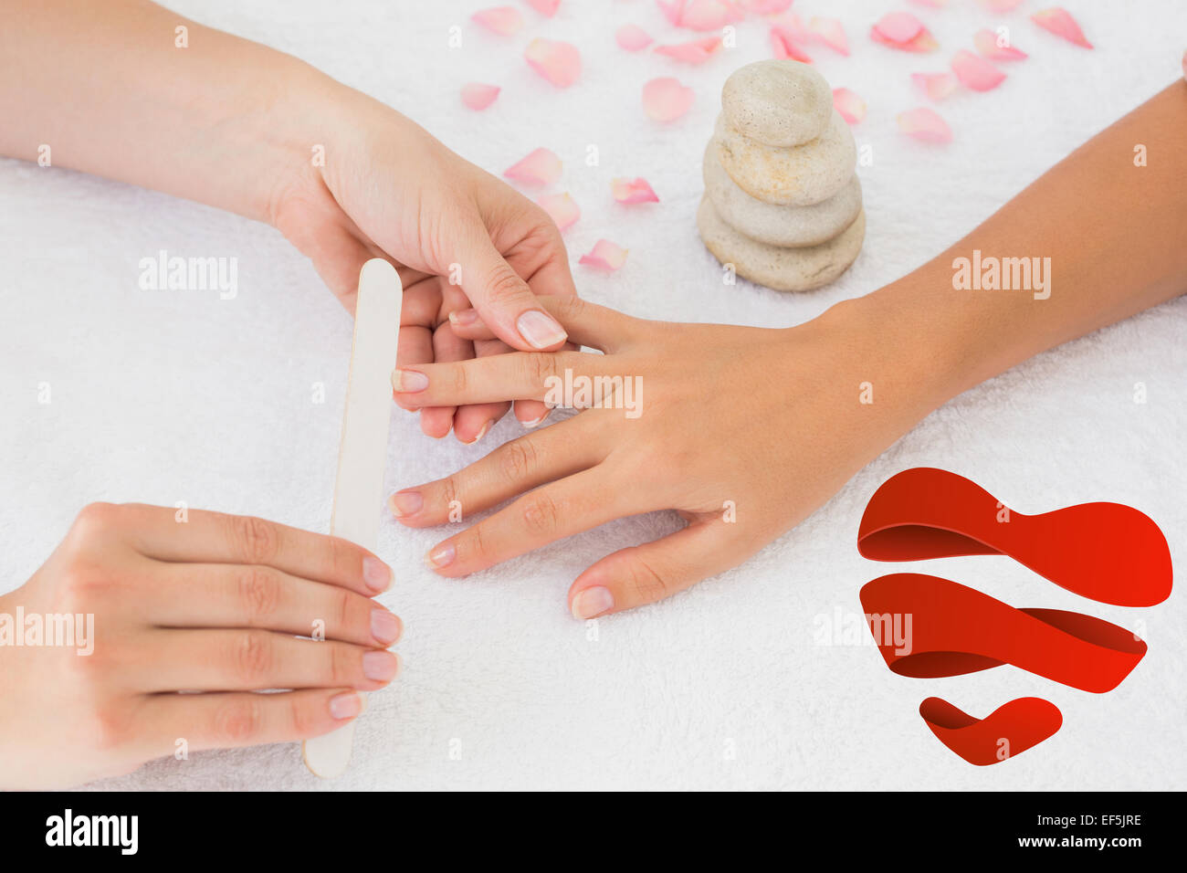 Composite image of nail technician filing customers nails Stock Photo