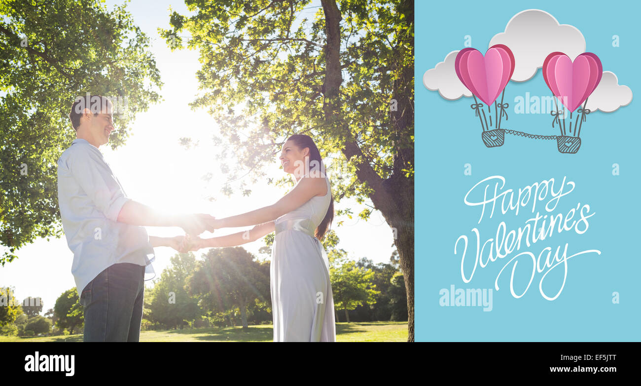 Composite image of loving young couple holding hands at park Stock Photo