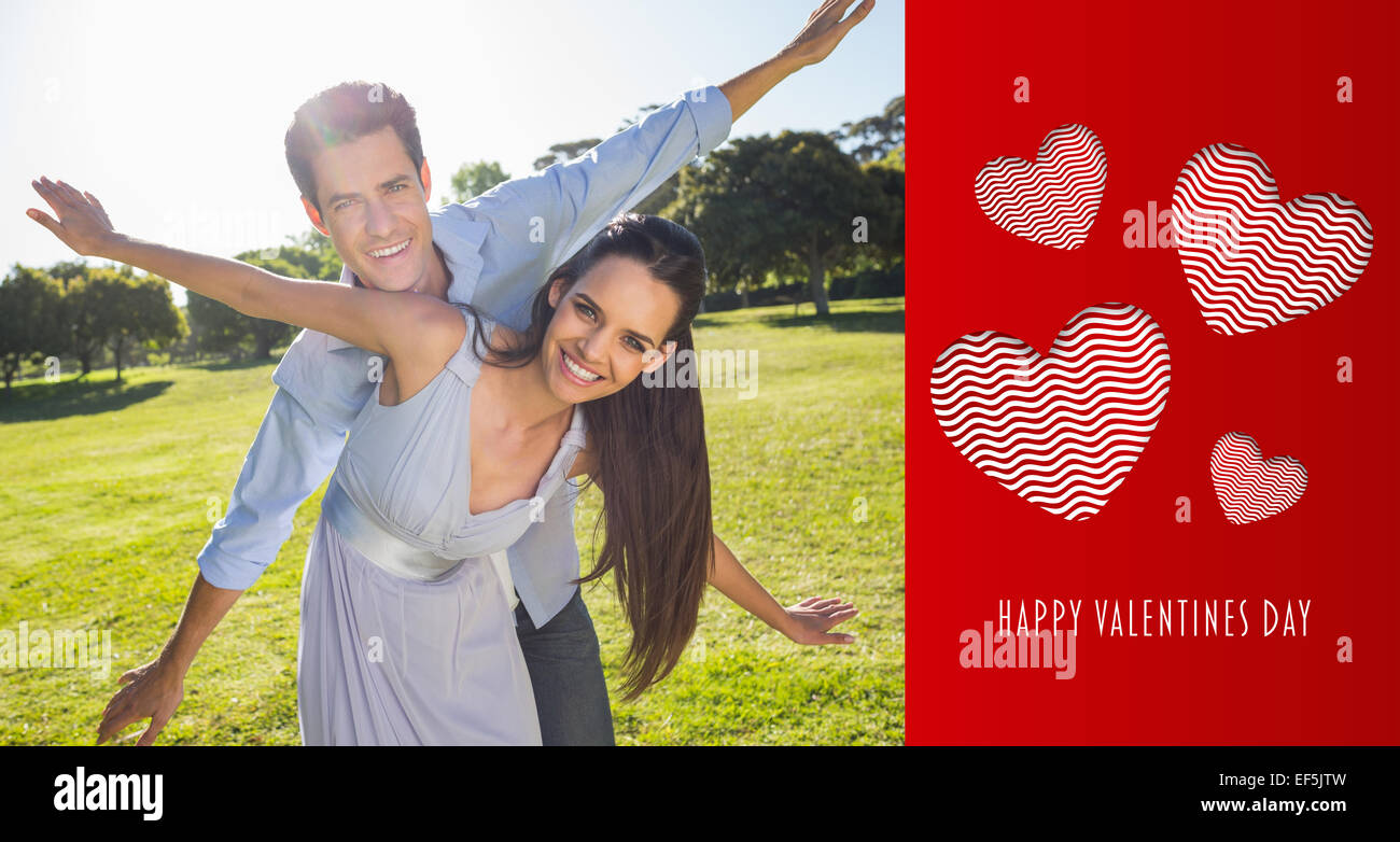 Composite image of happy couple with arms outstretched at park Stock Photo