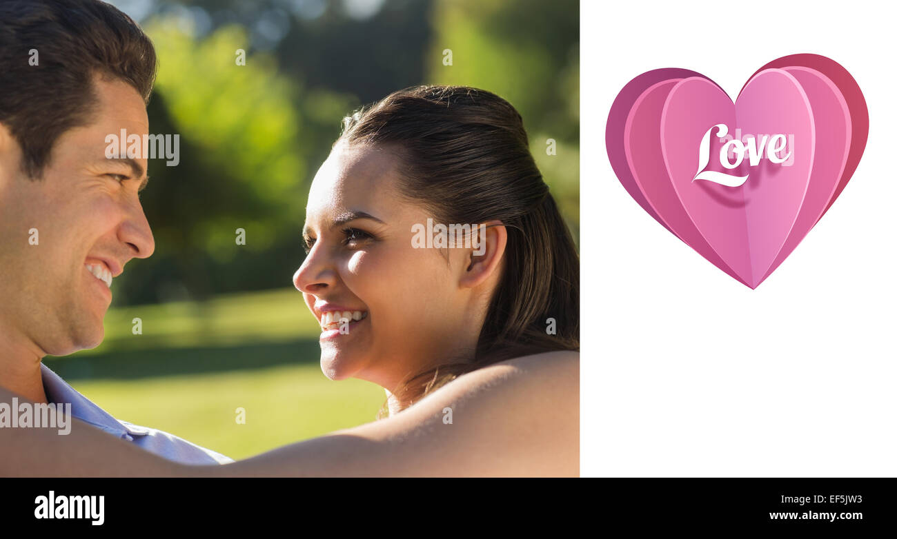 Composite image of loving and happy couple looking at each other at park Stock Photo