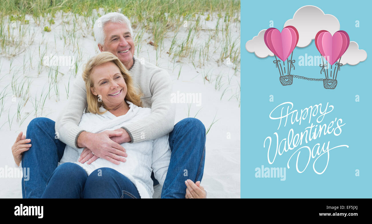 Composite image of romantic senior couple relaxing at beach Stock Photo