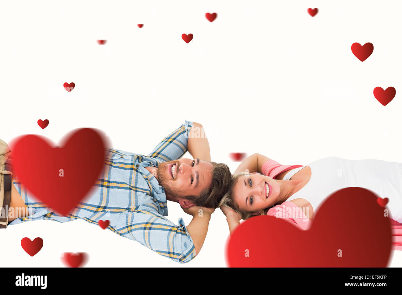 Composite image of attractive young couple lying smiling at camera ...