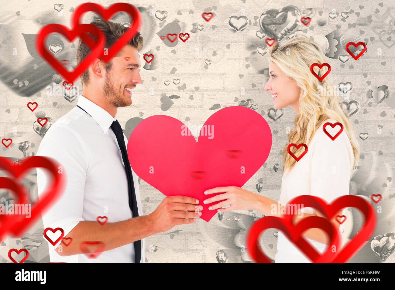 Composite image of attractive young couple holding red heart Stock ...