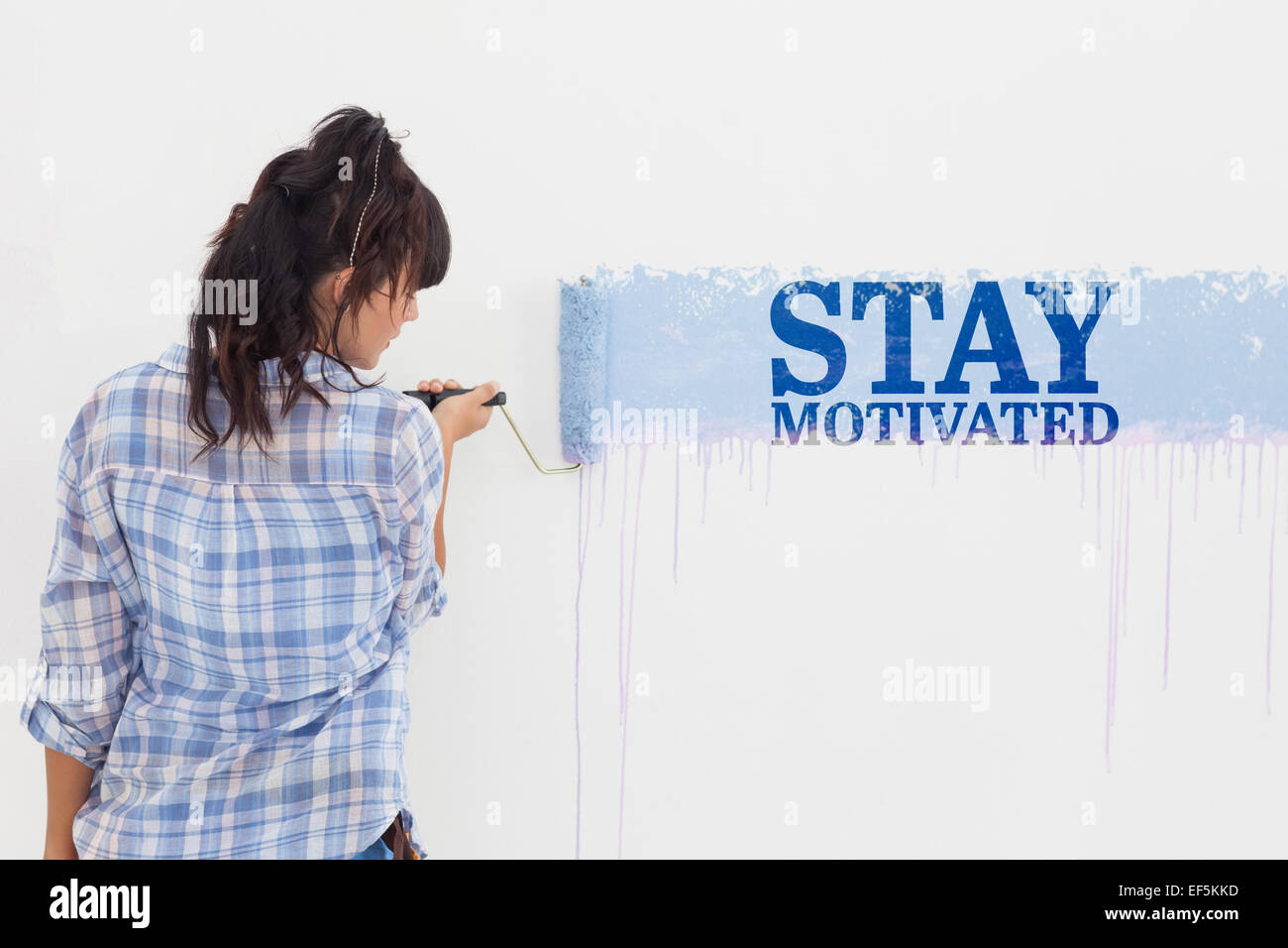 Composite image of woman painting wall blue Stock Photo