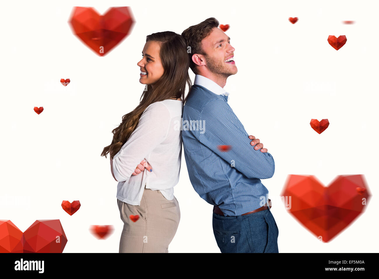 Composite image of happy young couple standing back to back Stock Photo