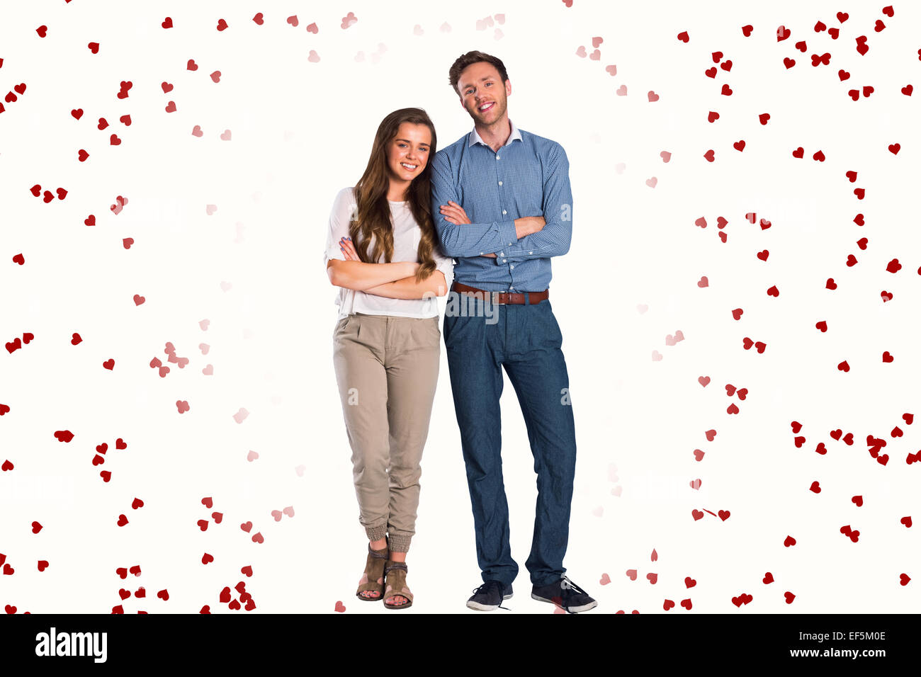 Composite image of smiling young couple with arms crossed Stock Photo