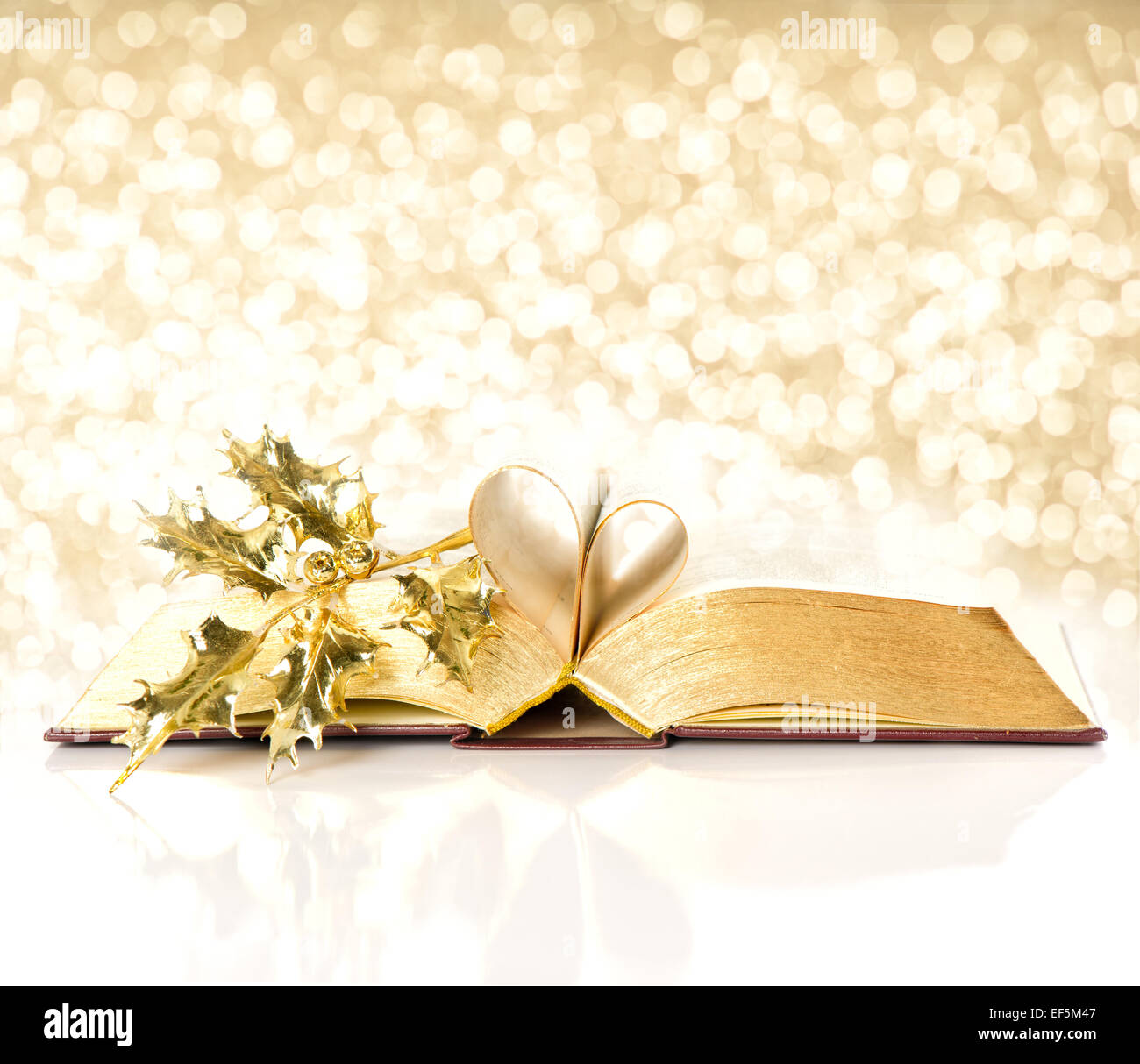 open vintage book with golden pages. bible with golden decoration. shiny lights christmas background Stock Photo
