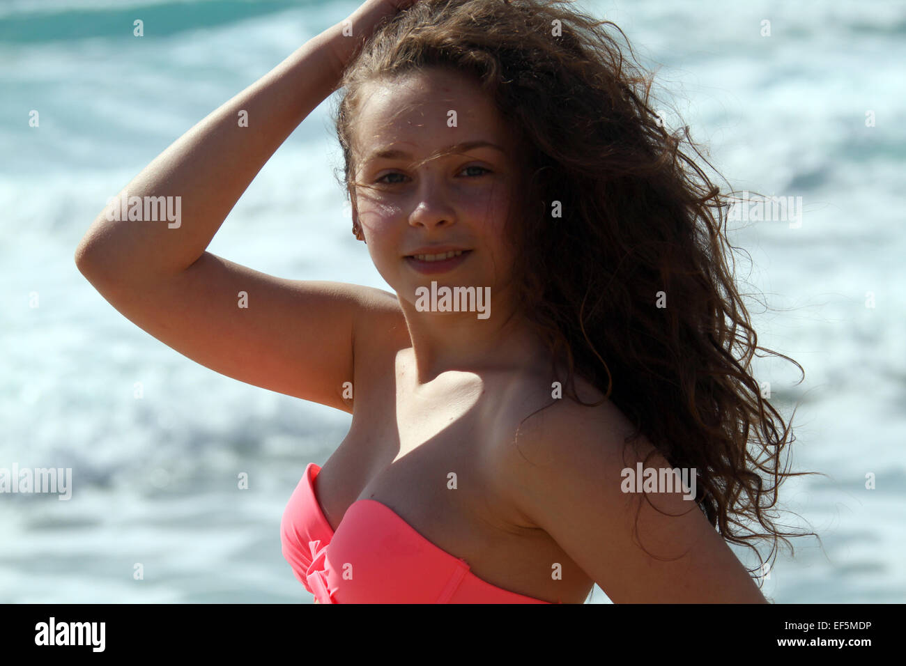 TEENAGE GIRL ON BEACH IN PINK BIKINI FALASARNA CRETE GREECE 30 April 2014 Stock Photo