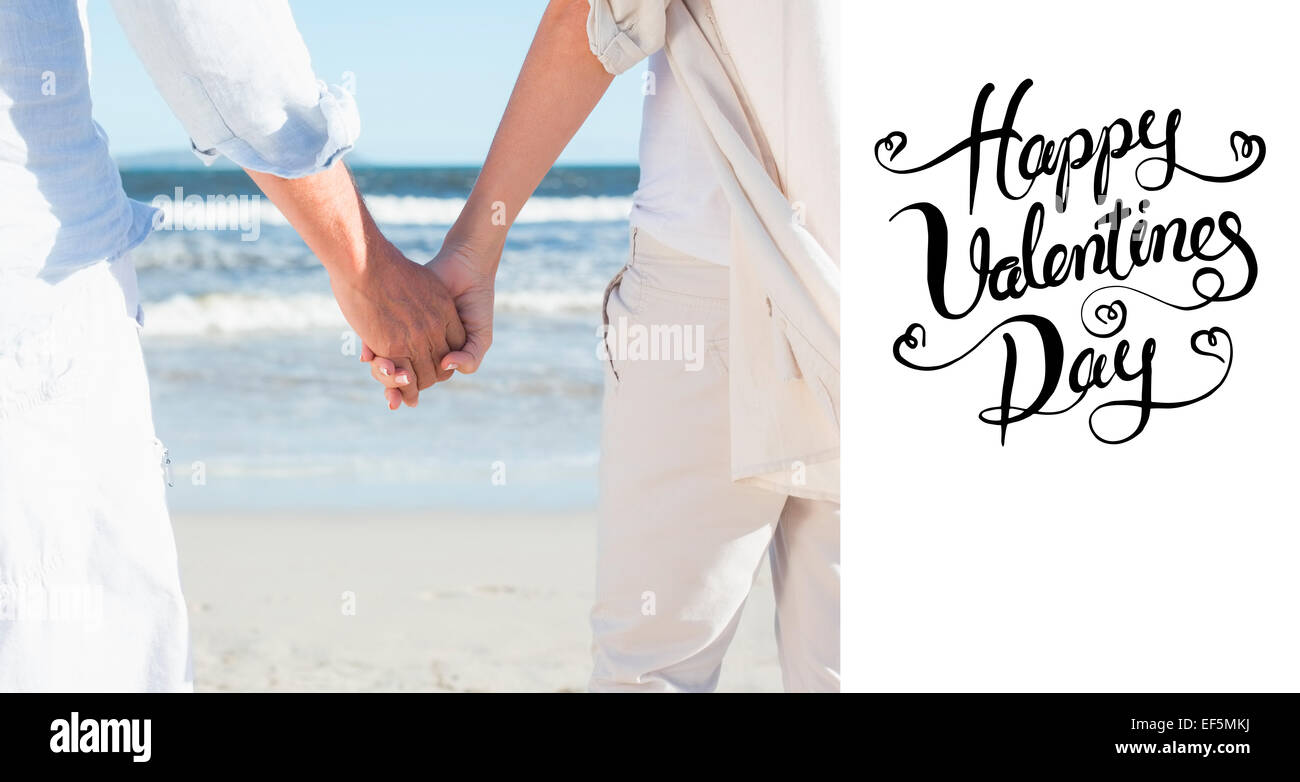 Composite image of couple on the beach looking out to sea holding hands ...