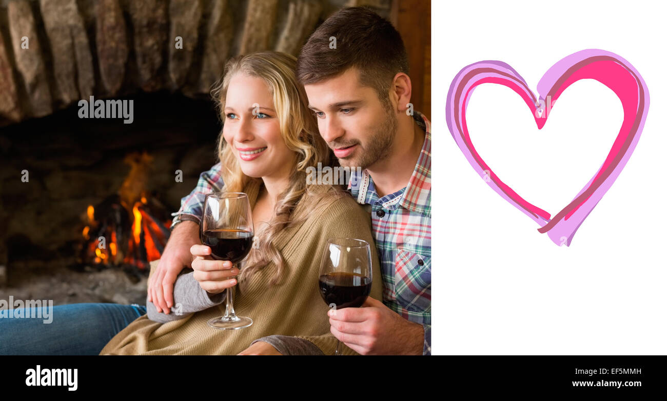 Composite image of couple with wineglasses in front of lit fireplace Stock Photo