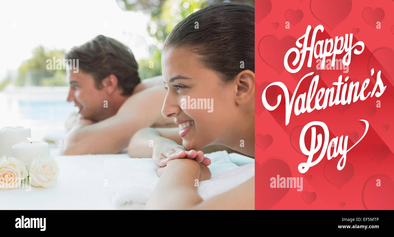 Composite image of couple lying on massage table at spa center Stock Photo