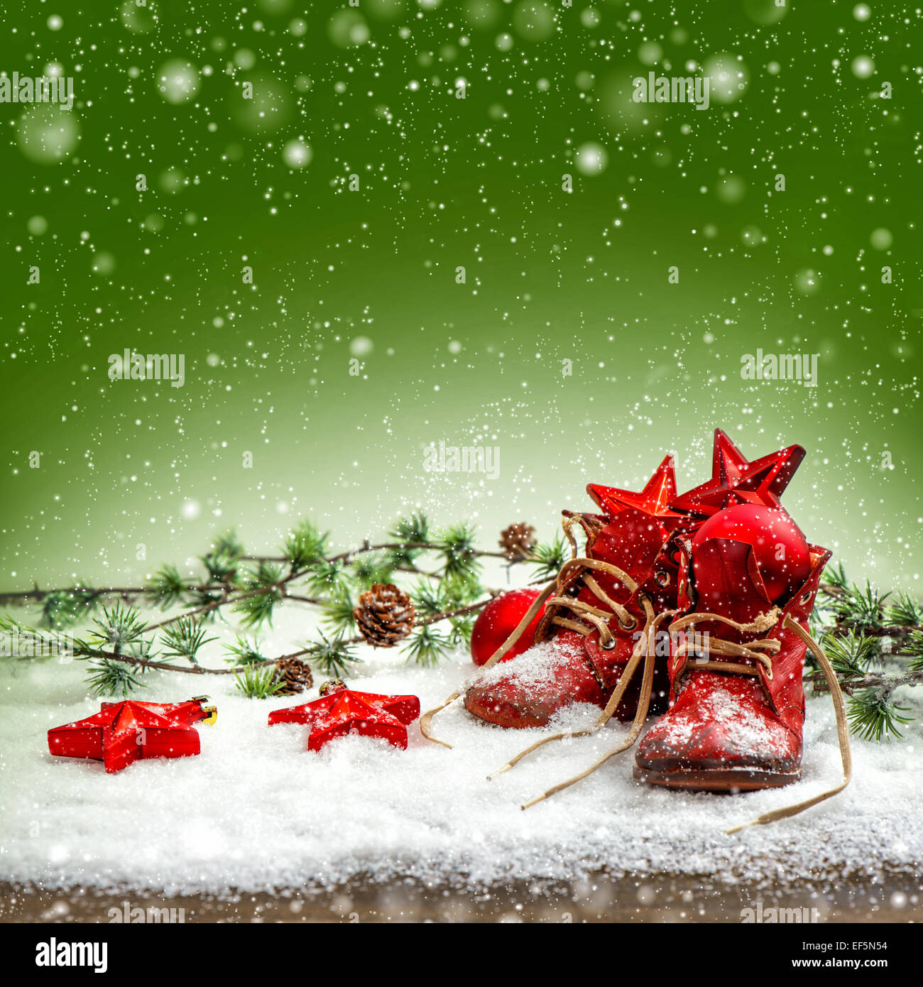 nostalgic christmas decoration with antique baby shoes. festive green background. retro style picture with snow effect Stock Photo
