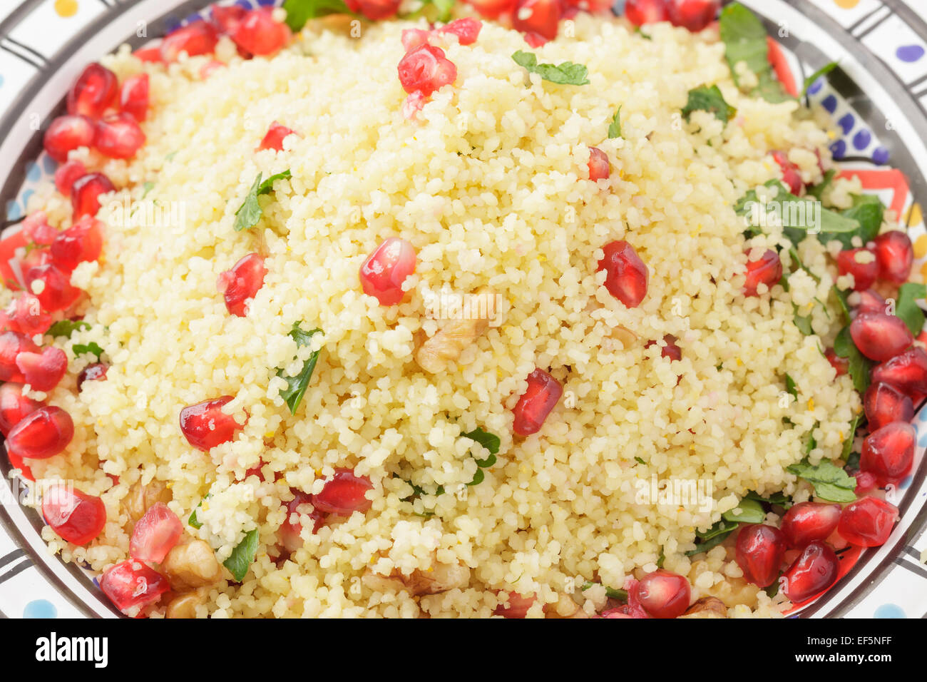 couscous with pomegranate seeds, walnuts and parsley Stock Photo