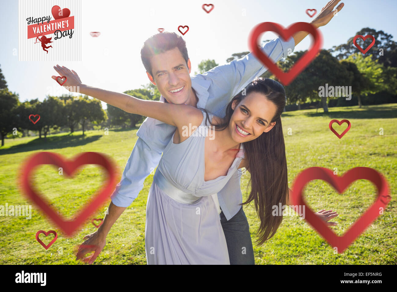 Composite image of happy couple with arms outstretched at park Stock Photo