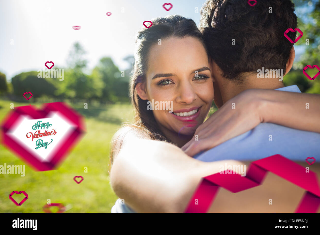 Composite image of loving and happy woman embracing man at park Stock Photo