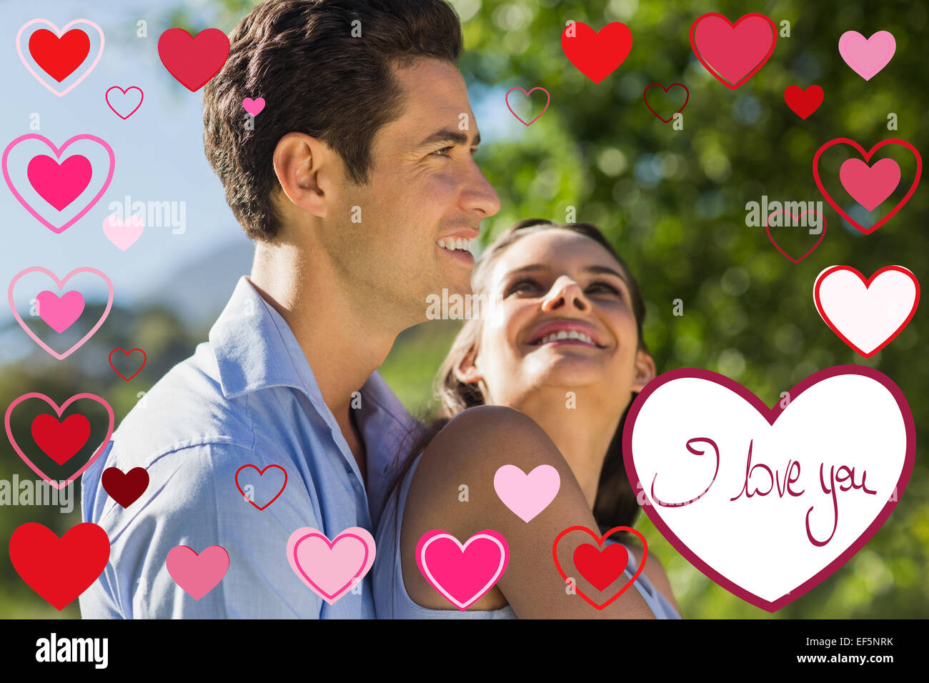 Composite image of loving and happy young couple at park Stock Photo