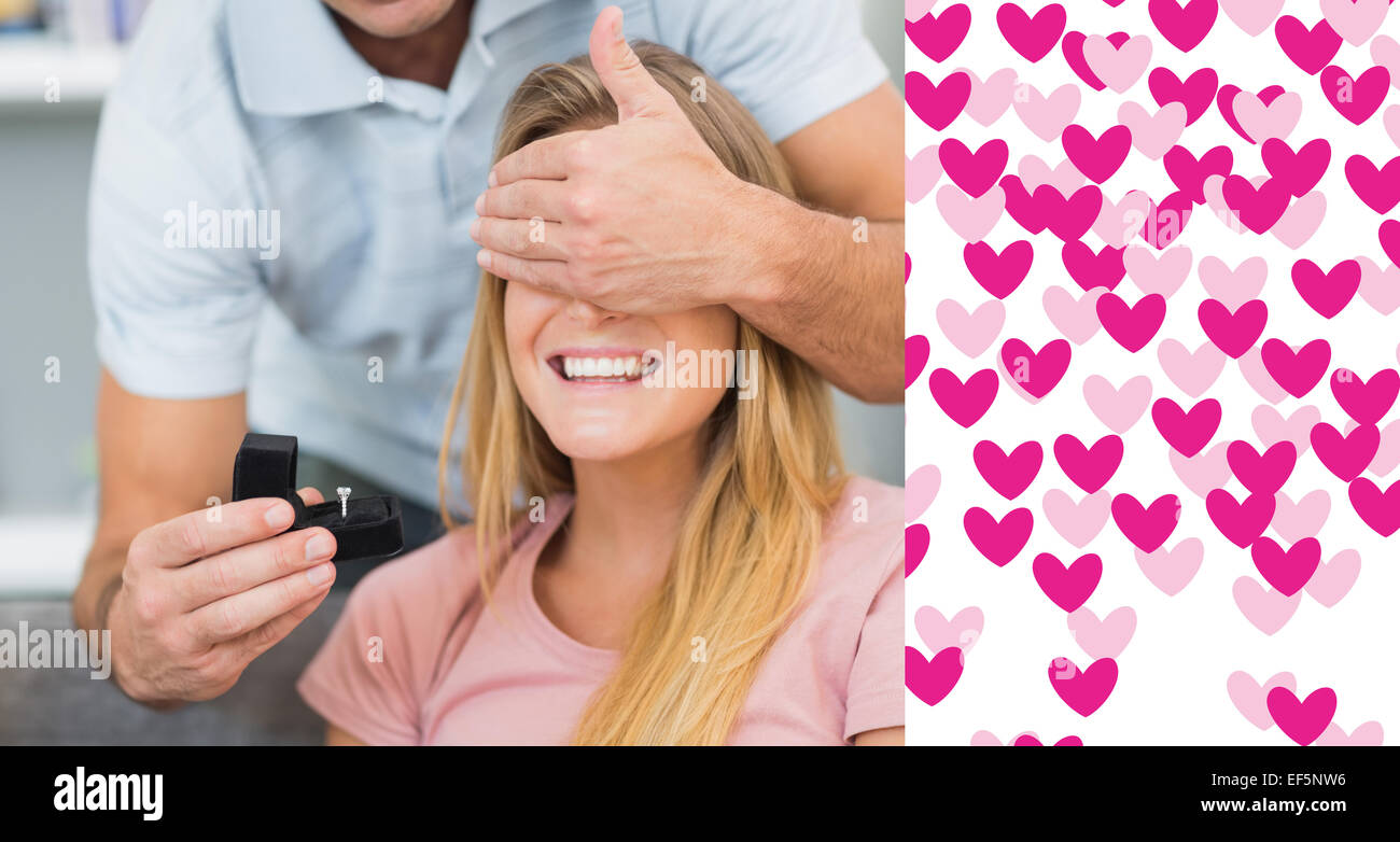 Composite image of man about to propose to his girlfriend on the sofa Stock Photo