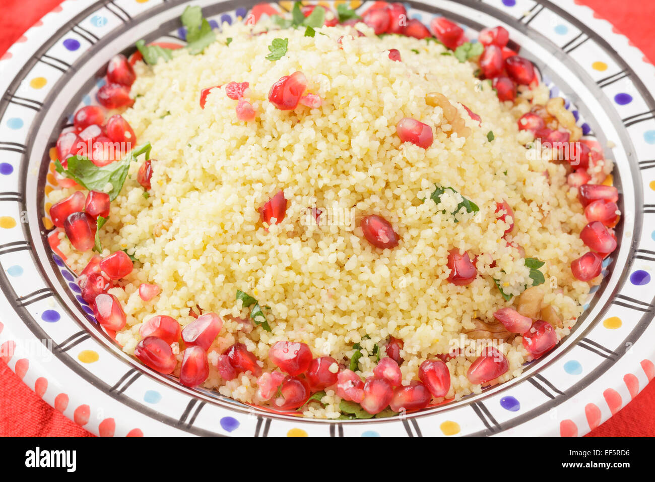 couscous with pomegranate seeds, walnuts and parsley Stock Photo