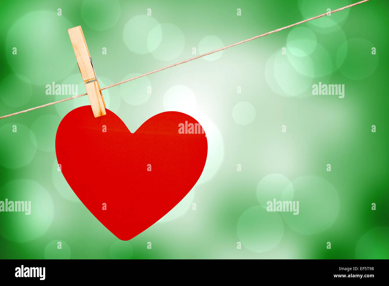 Composite image of heart hanging on line Stock Photo