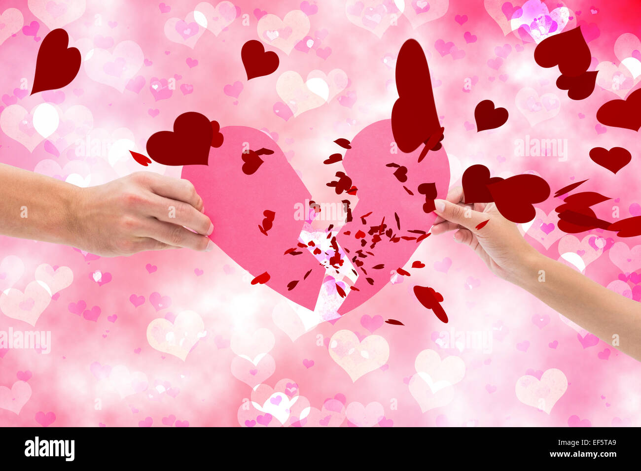 Composite image of hands holding two halves of broken heart Stock Photo