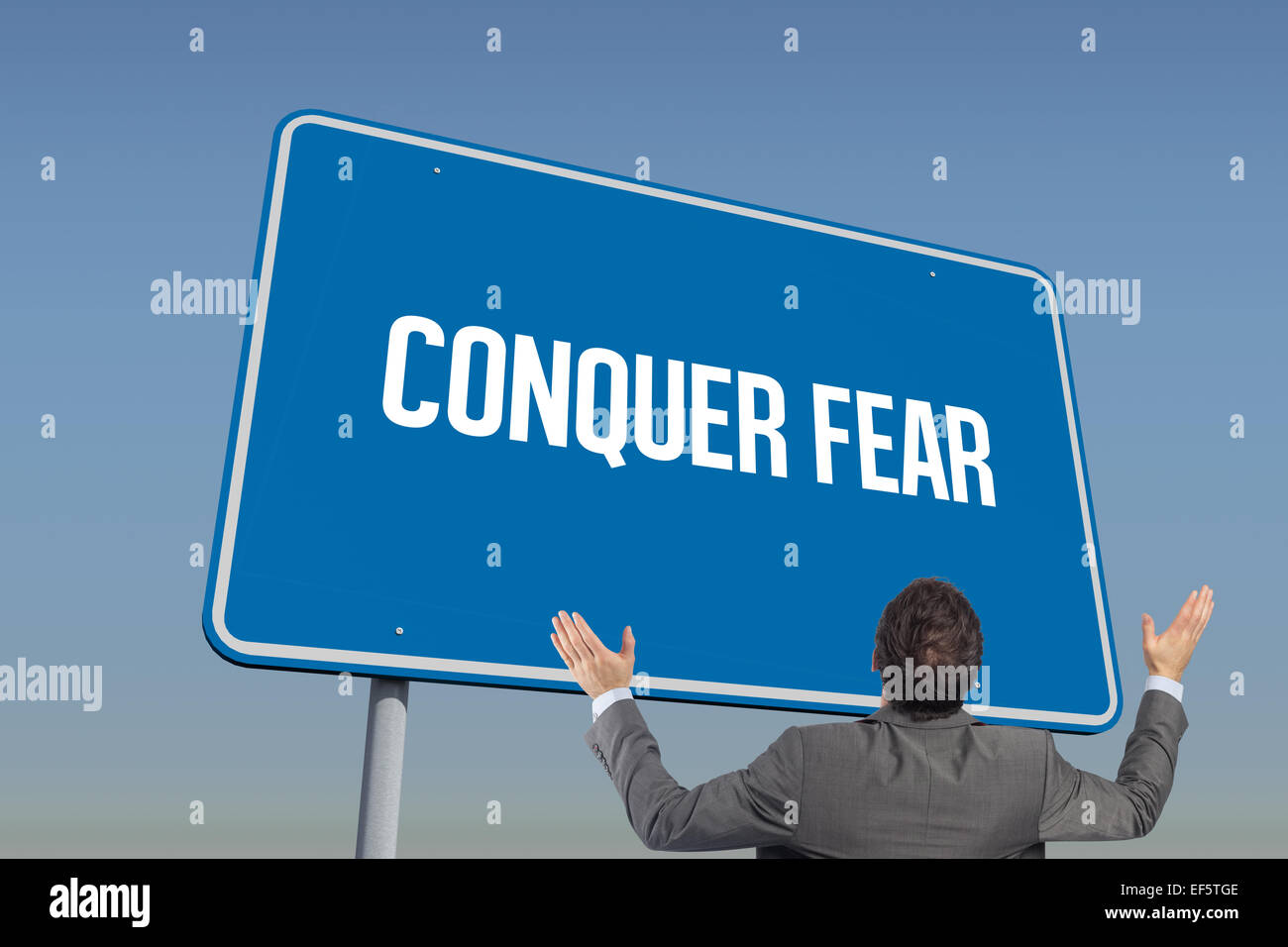 Conquer fear against blue sky Stock Photo