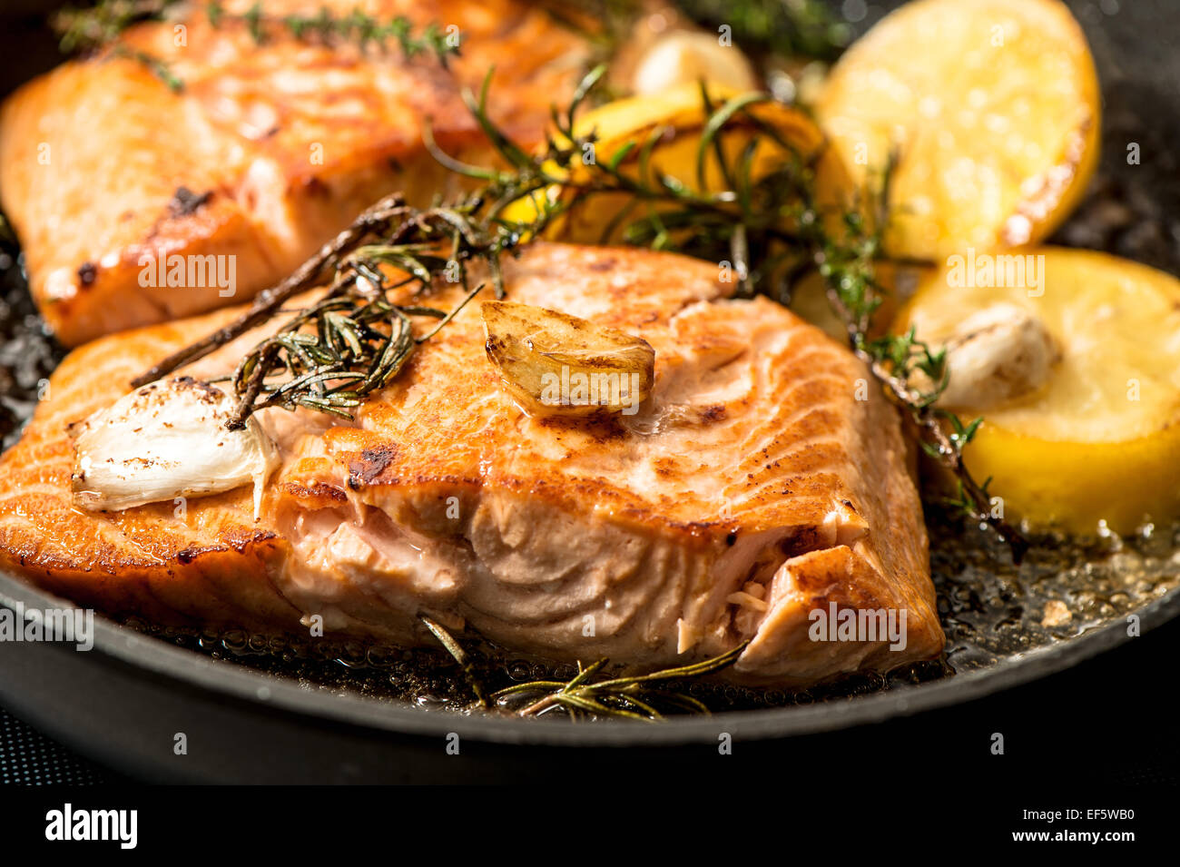 Grilled salmon fish with herbs, garlic and lemon. Closeup, selective