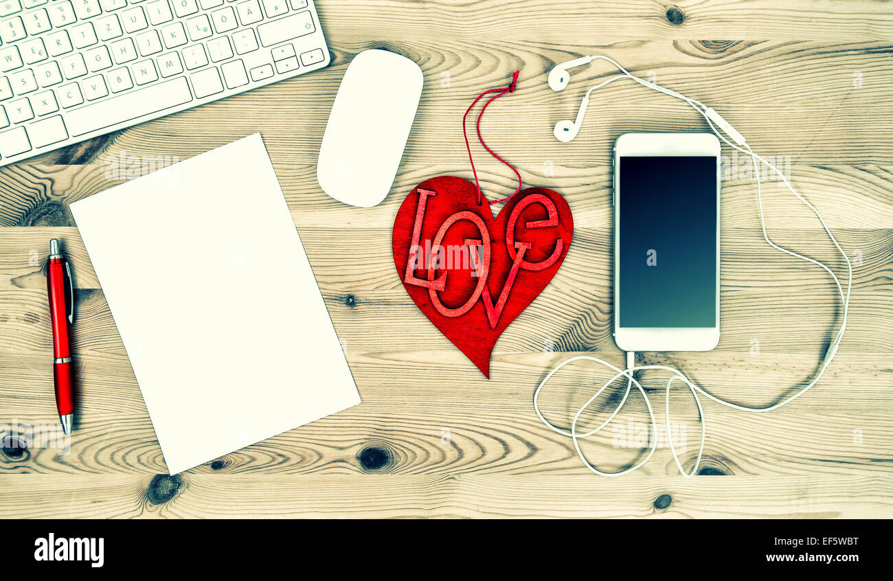 Workstation with Red Valentine Heart, Stationary and Office Supplies. Vintage style toned picture Stock Photo