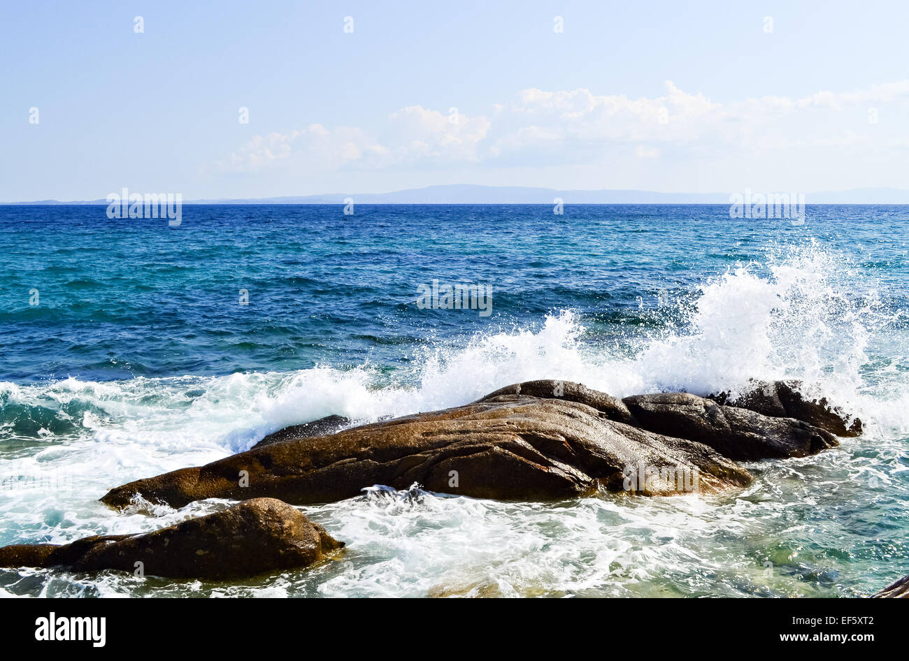 Waves splash against rocks in beautiful summer day Stock Photo - Alamy