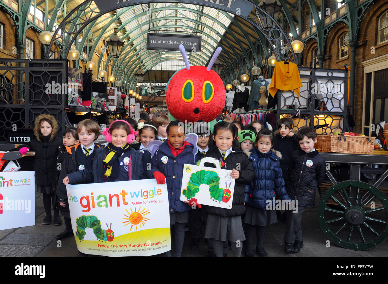 London, UK, 27 January 2015, Pupils from ST Clement's Dabes school. London's historic Apple Market in Covent Garden was transformed into a scene from The Very Hungry Caterpillar as TV presenter Laura Hamilton with one year old son Rocco and pupils from ST Clements Danes school teamed up with leading charity Action for Children to launch the annual fundraising campaign for children, The Giant Wiggle, taking place on 19 March . Credit:  JOHNNY ARMSTEAD/Alamy Live News Stock Photo