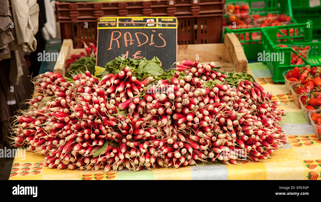 Radishes on yellow table cloth at market in Lyon, France Stock Photo