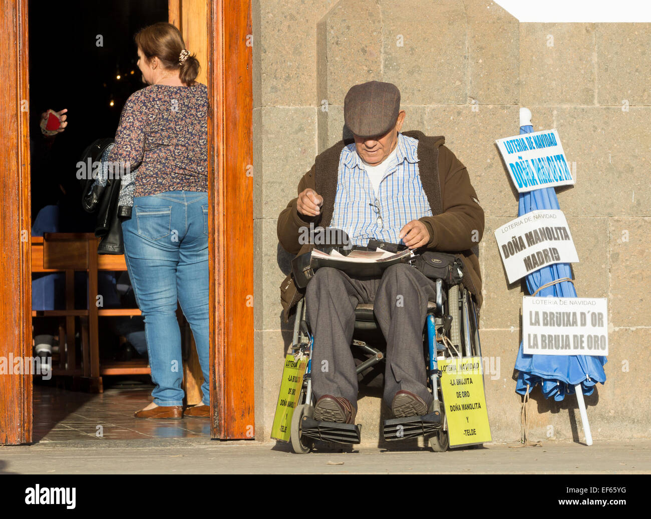 Spanish man selling Lotto ( Spanish Lottery) tickets for 'El Gordo' outside village church in Spain Stock Photo
