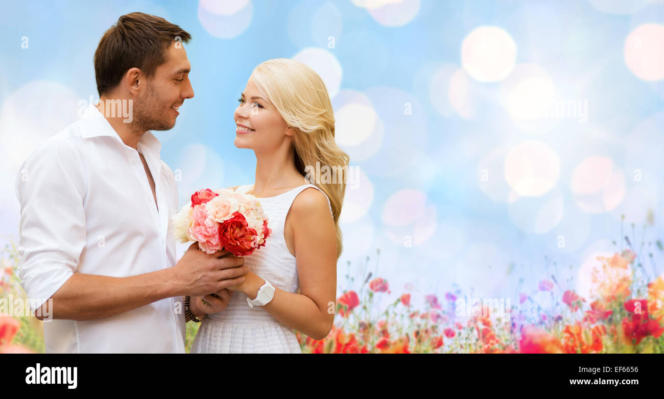 happy couple with flowers over lights background Stock Photo - Alamy