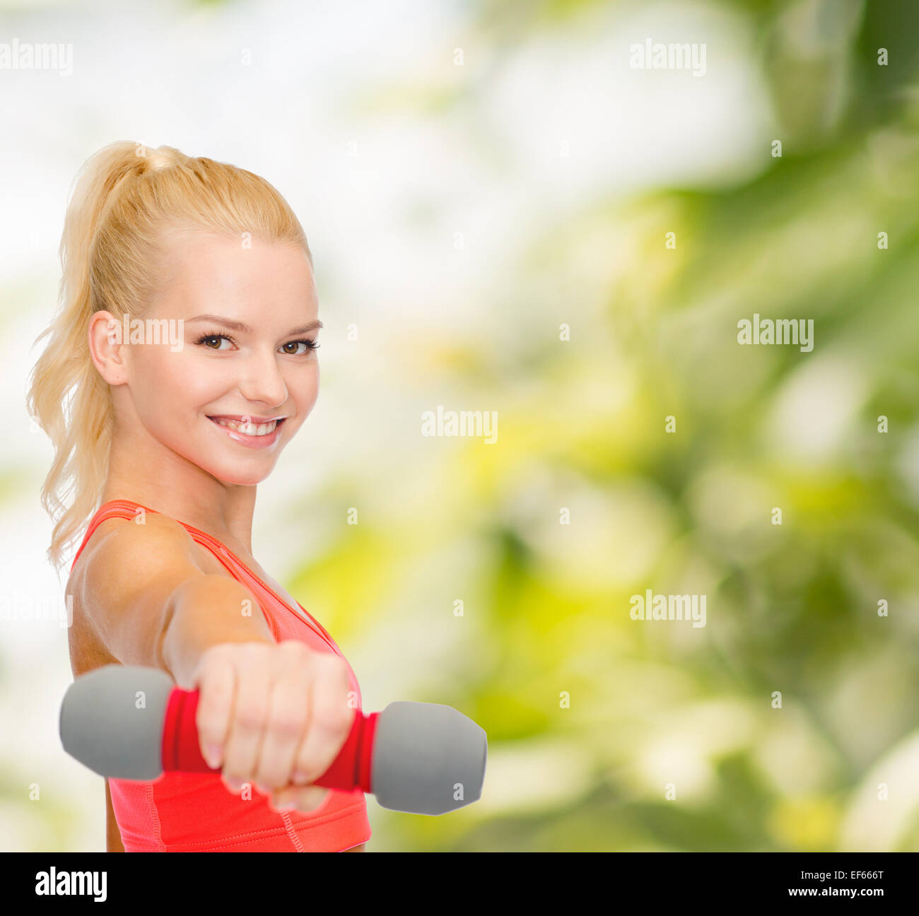 smiling beautiful sporty woman with dumbbell Stock Photo