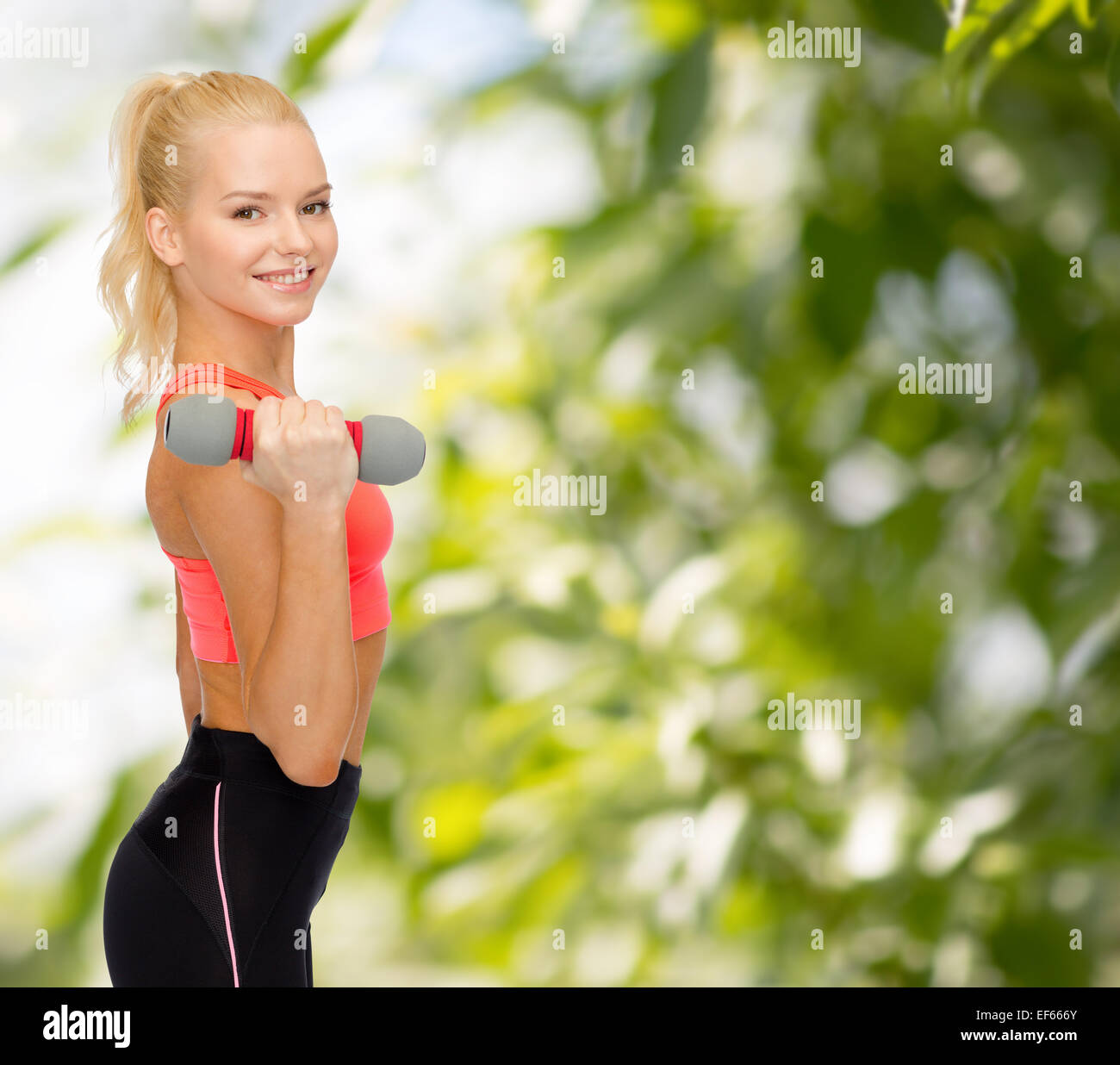 smiling beautiful sporty woman with dumbbell Stock Photo