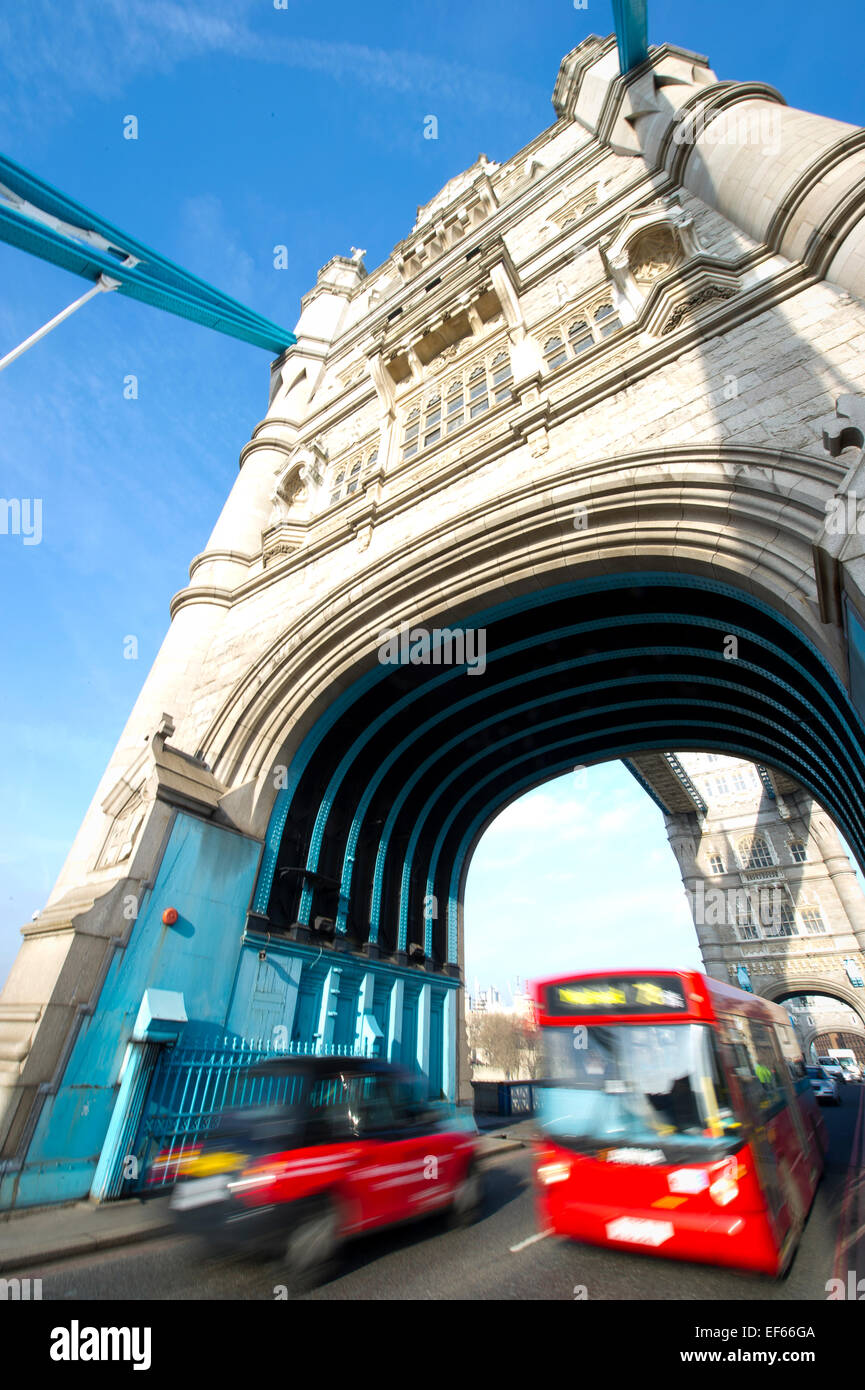 LONDON, UK A single-decker red bus passes a black taxi on Tower Bridge. Stock Photo