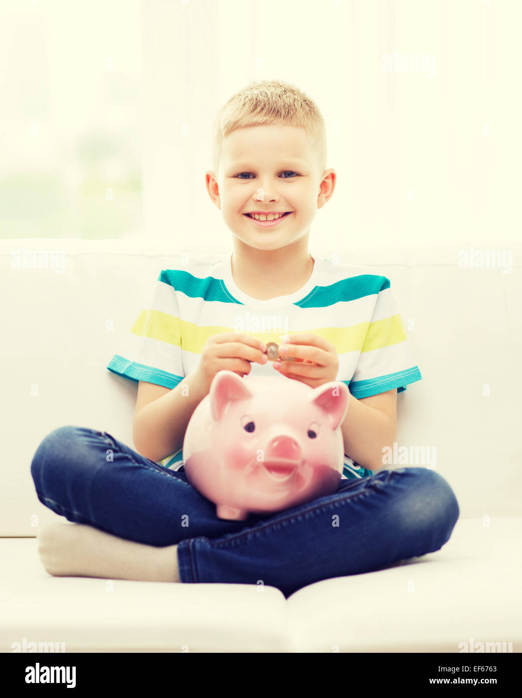 smiling little boy with piggy bank and money Stock Photo - Alamy