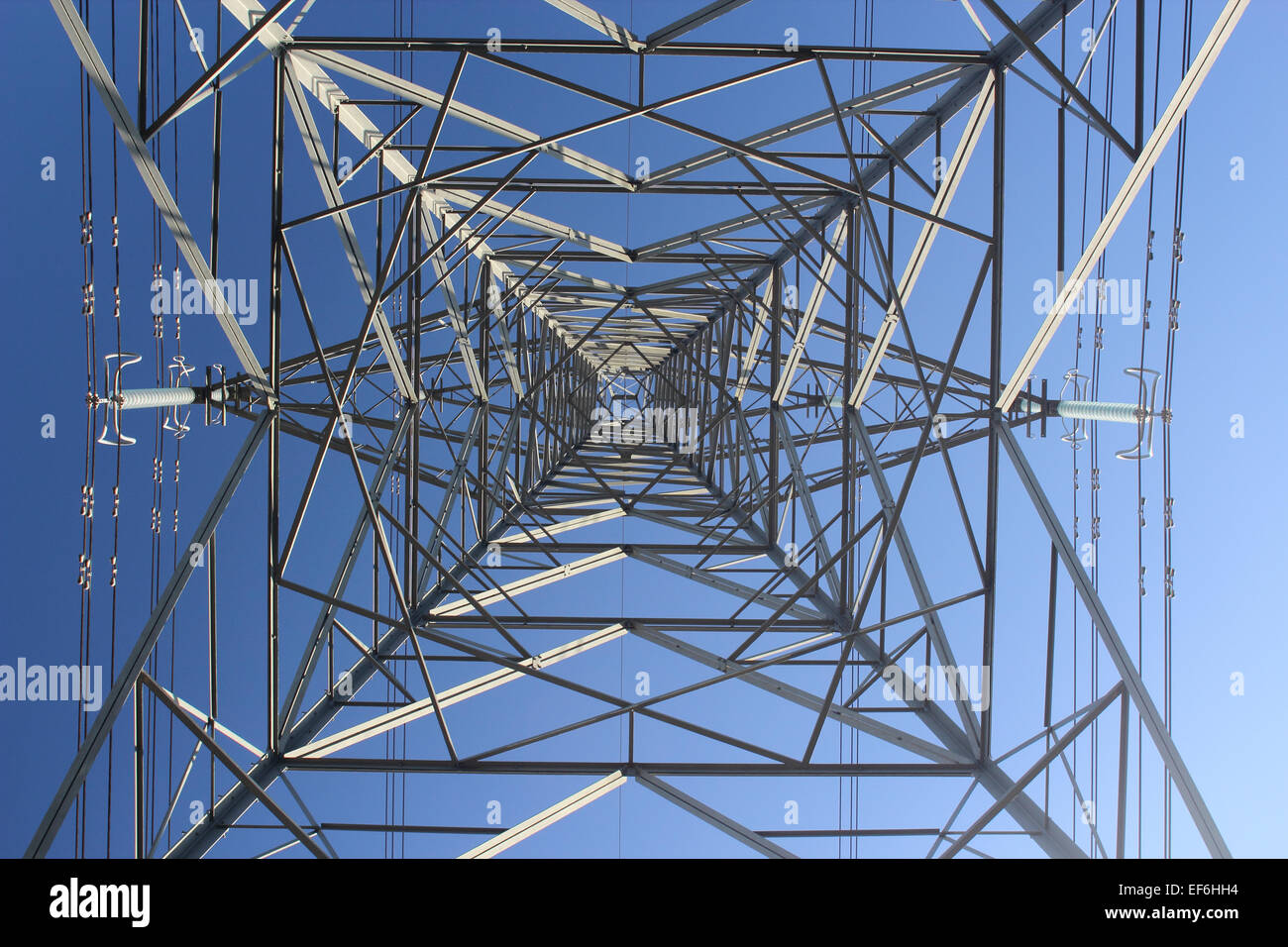 Power Pylon from underside against a Blue Sky Stock Photo
