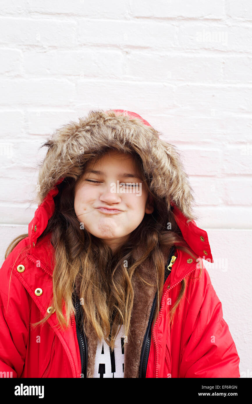 young girl with coat making silly face Stock Photo