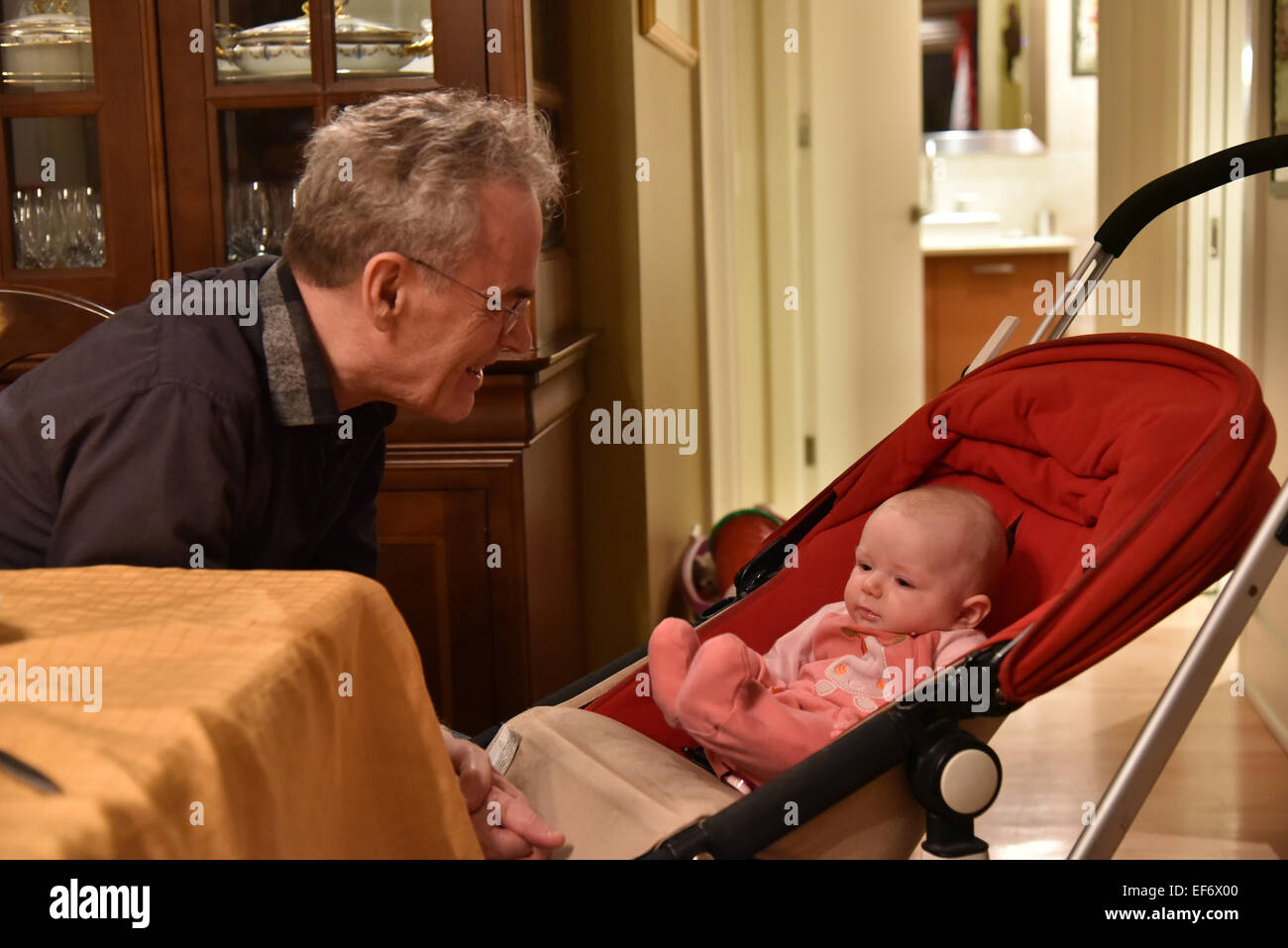 A grandfather talking to his 5 month old grand-daughter Stock Photo