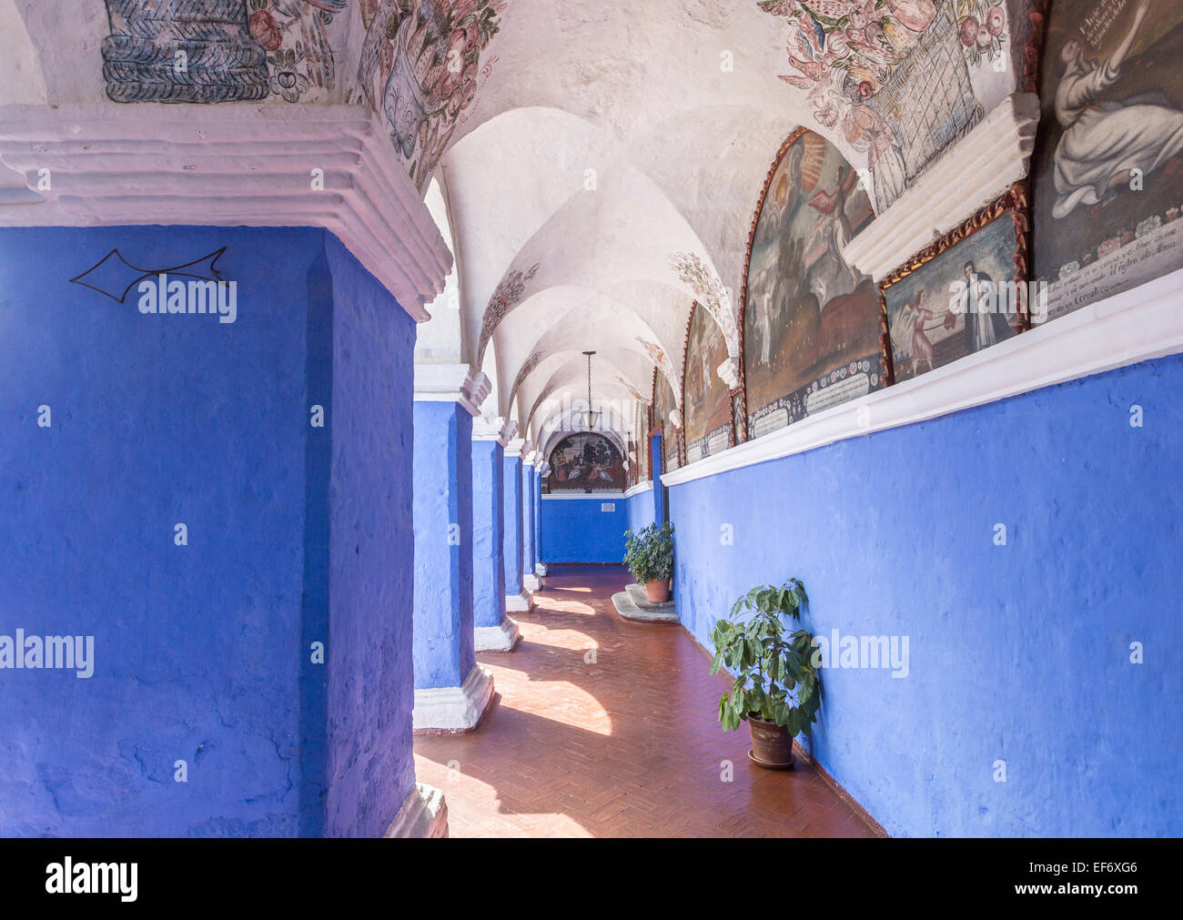 Peruvian sightseeing: Cloisters with blue walls, columns and fresco paintings inside the iconic Santa Catalina Convent in Arequipa, Peru Stock Photo