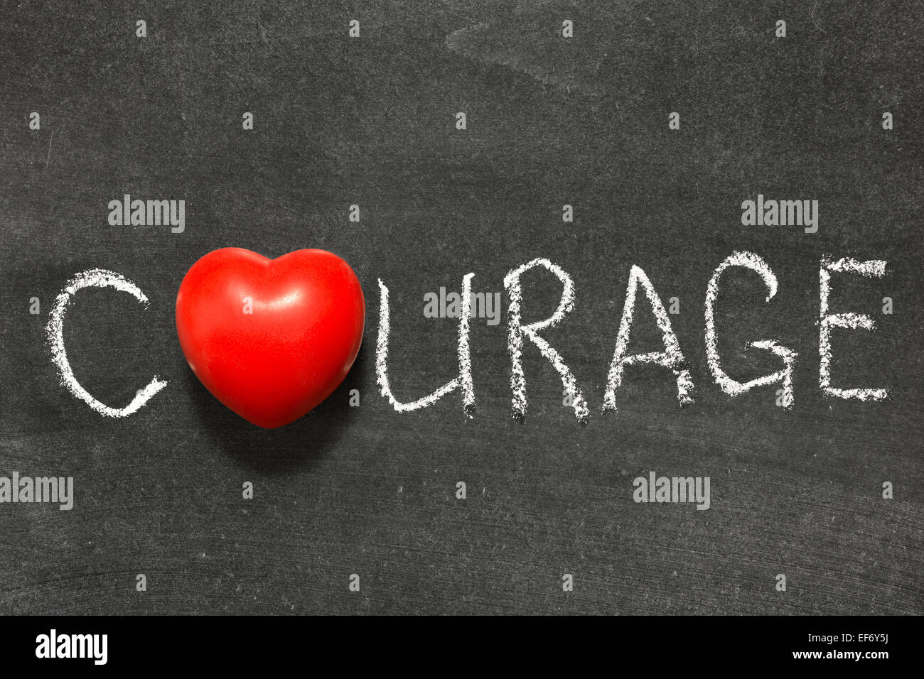 courage word handwritten on  chalkboard with heart symbol instead of O Stock Photo