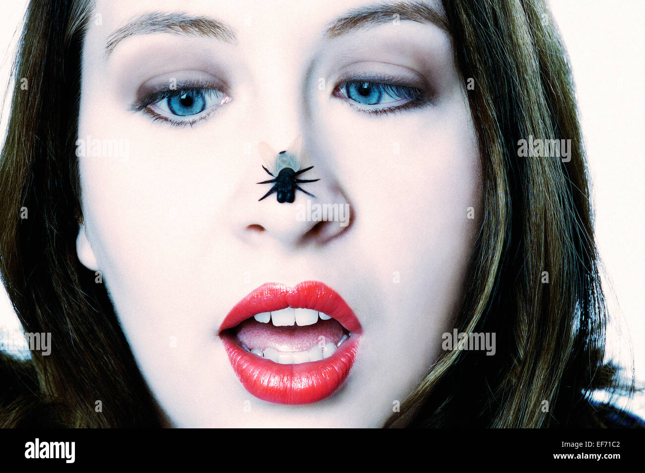 Pretty woman looking at bug on her nose. Stock Photo