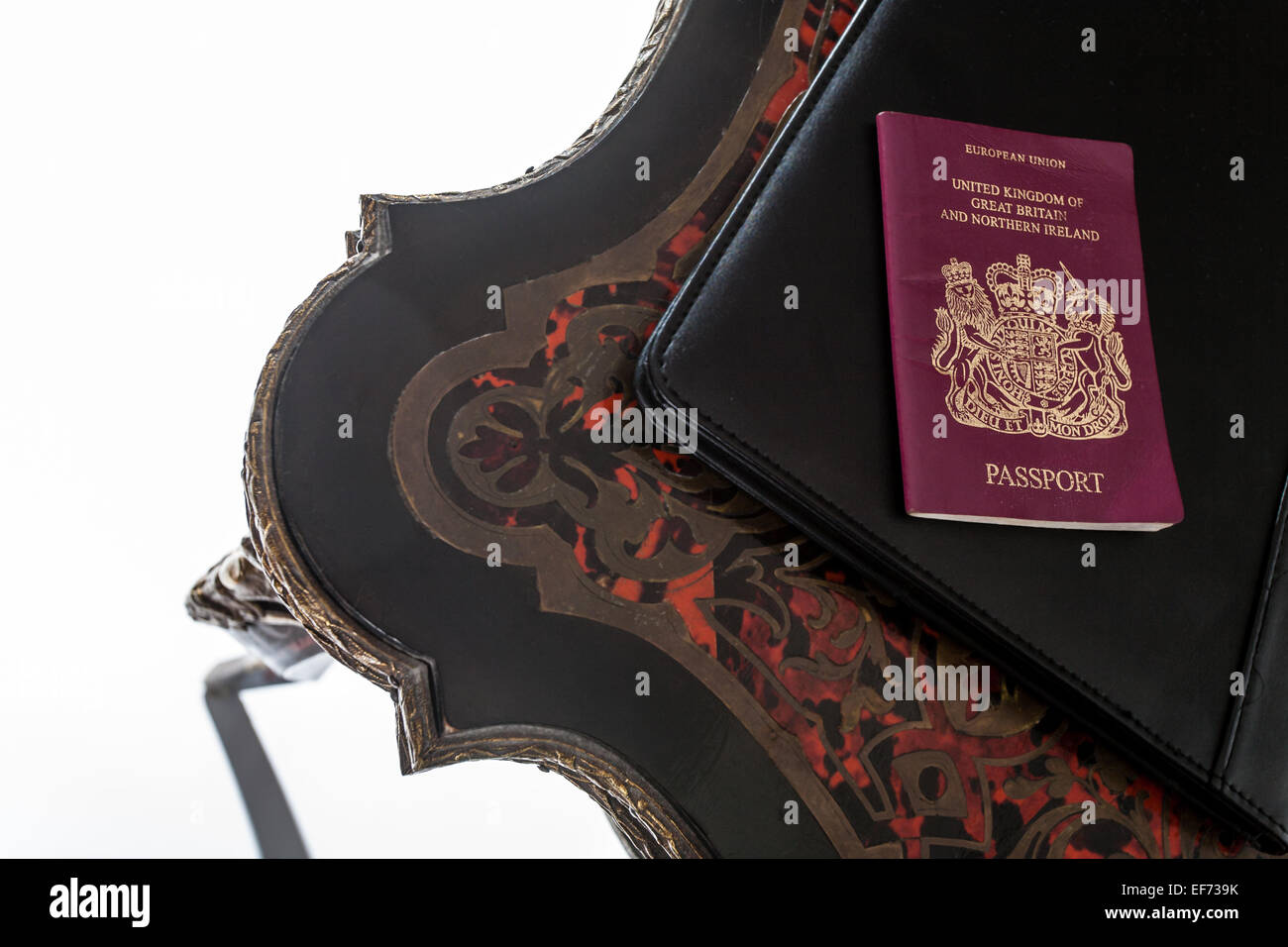A United Kingdom passport sitting on a Buhl table. Stock Photo